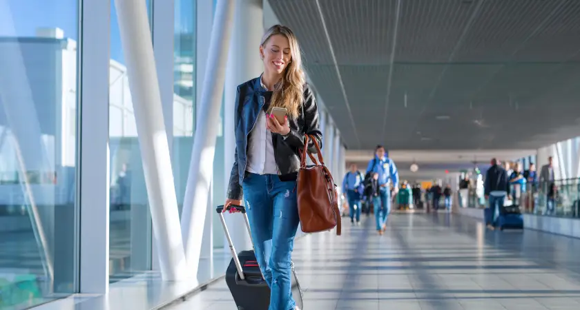 žena s cestovním kufrem na letišti